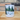front view Tumbler with 'Rainy Lake' design featuring trees and a lake on a wooden surface.