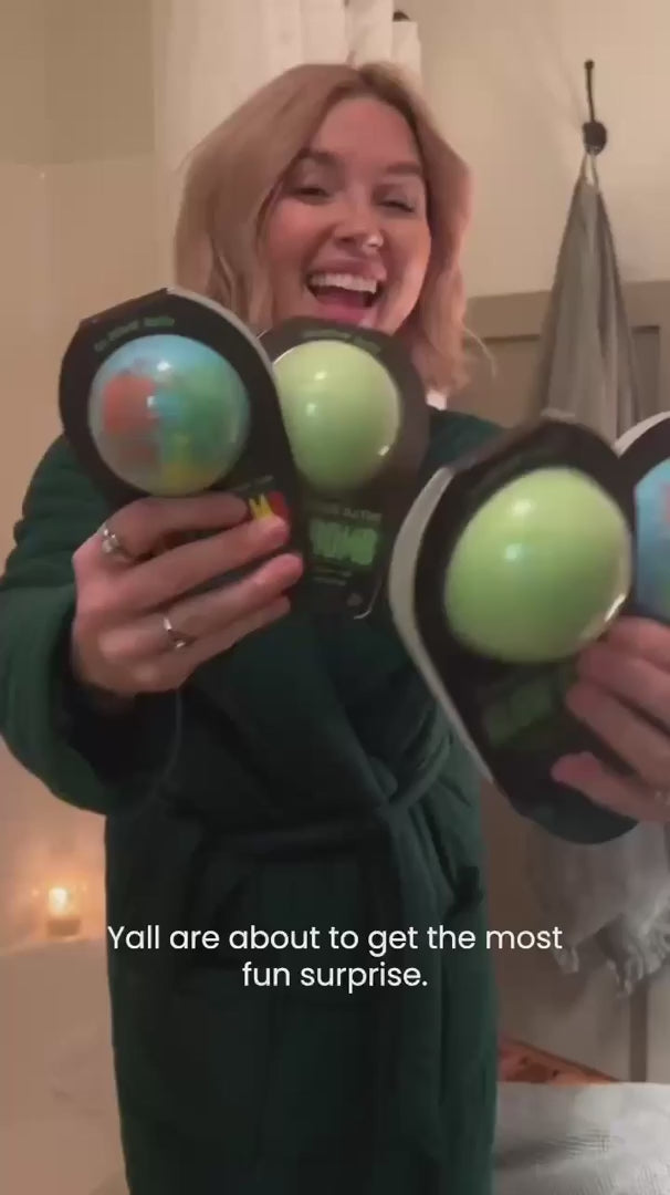 video of a woman holding three glow in the dark bath bombs and dropping them into bath to see them glow